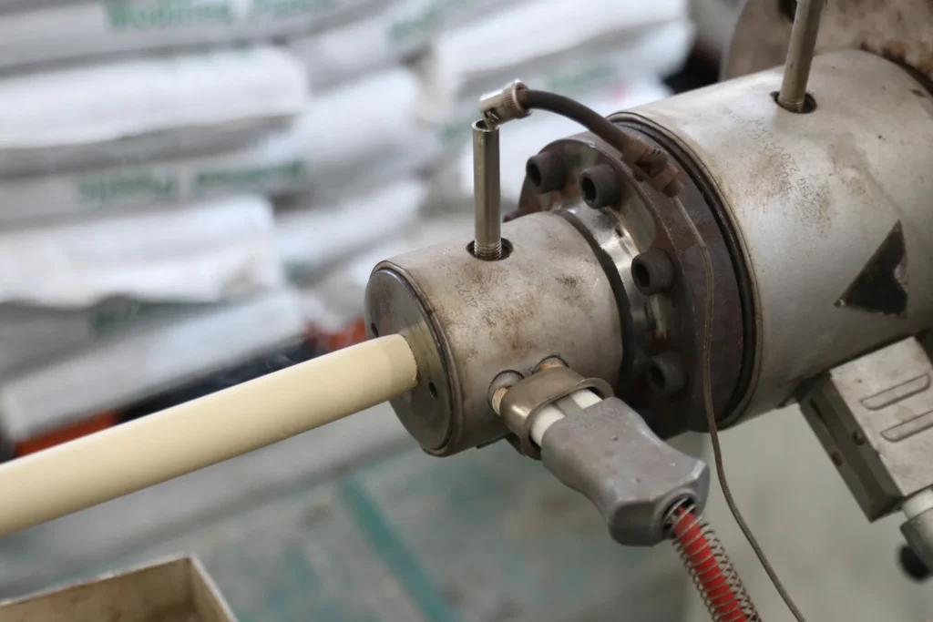 PPR pipe emerging from the extruder die head on a Bekaatherm production line
