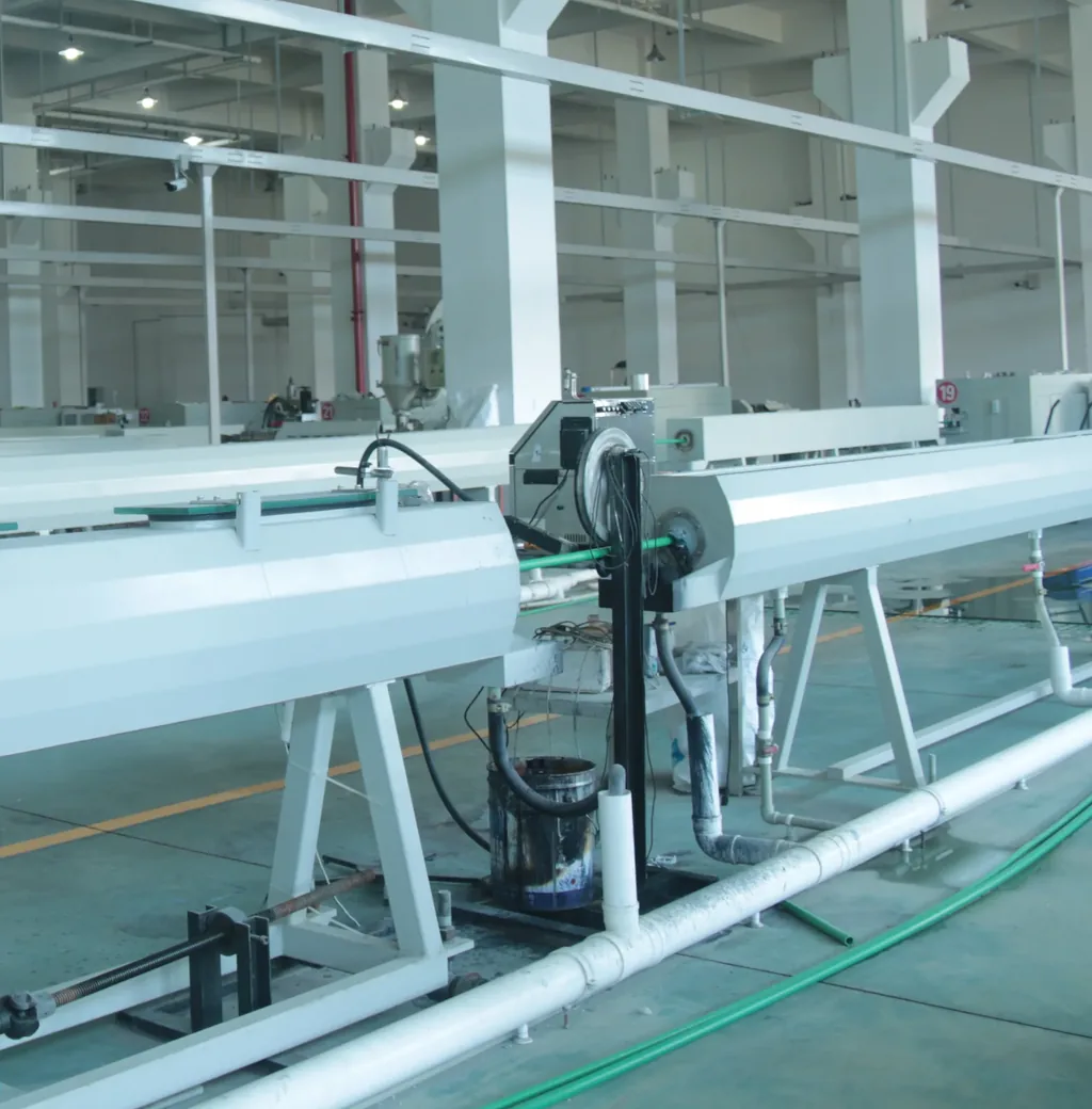Extrusion line producing pipe, with the haul-off and cutting section visible at the end of the run