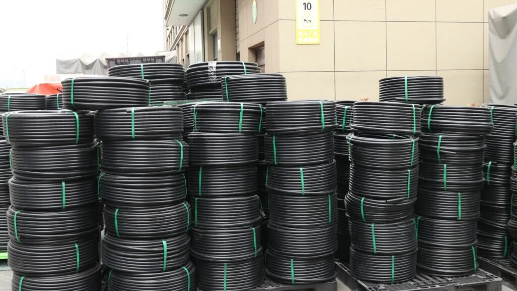 Bundles and coils of black HDPE pipe in several diameters, the stock a per-metre quote actually refers to