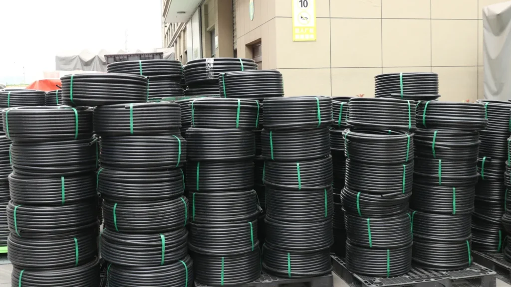 Coiled black HDPE pressure pipe stacked for shipment, the material an electrofusion coupling has to be scraped onto before it will fuse